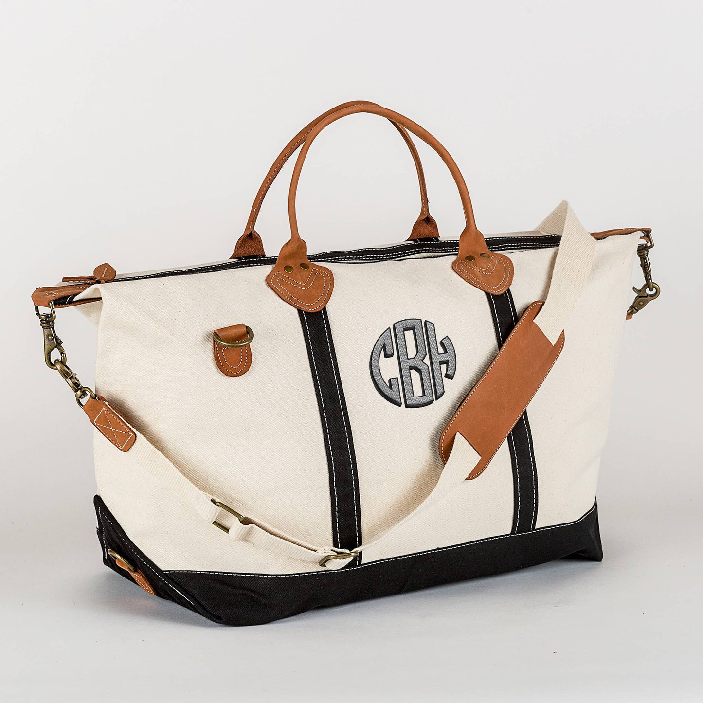 Black canvas weekender bag with leather trim and brass hardware