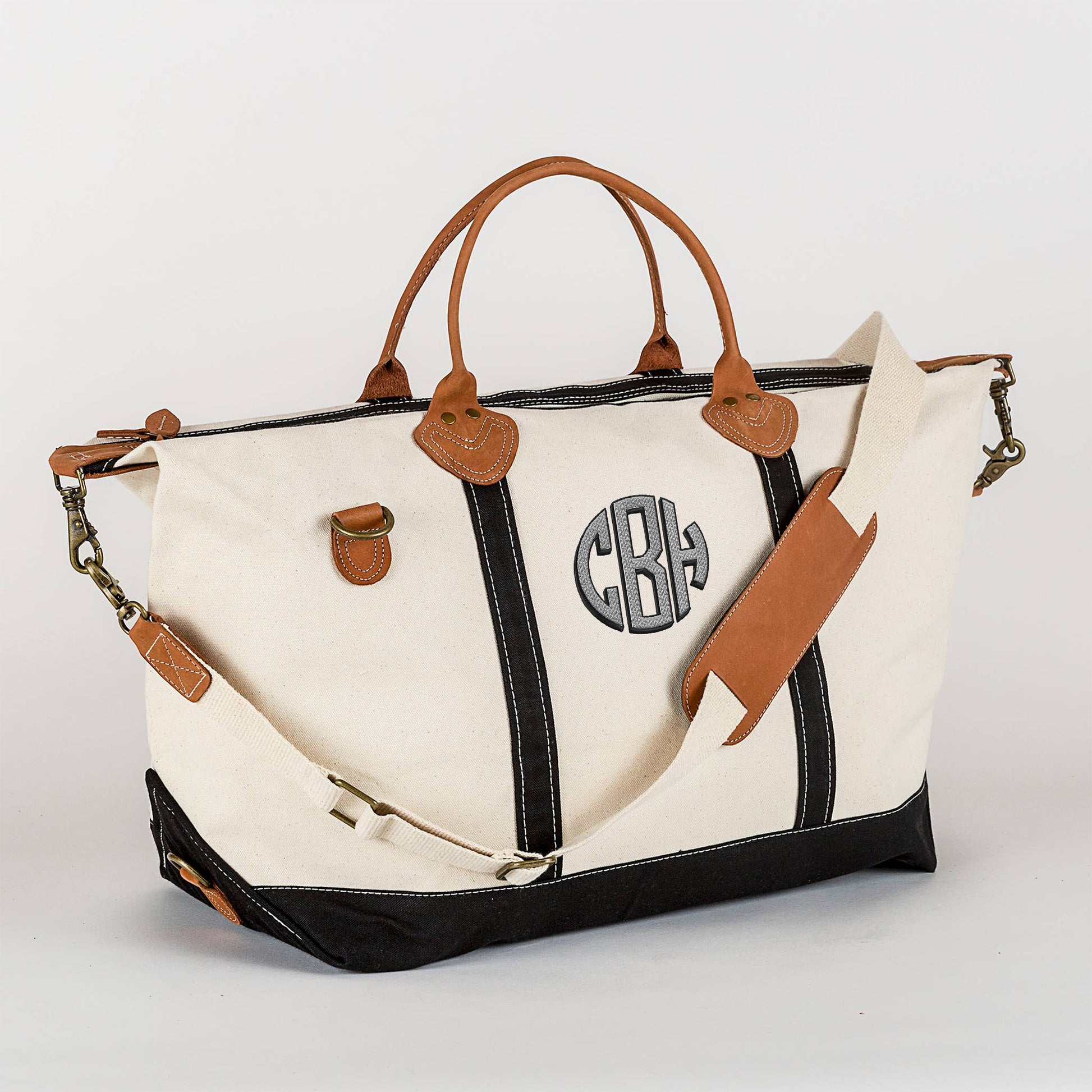 Black canvas weekender bag with leather trim and brass hardware

