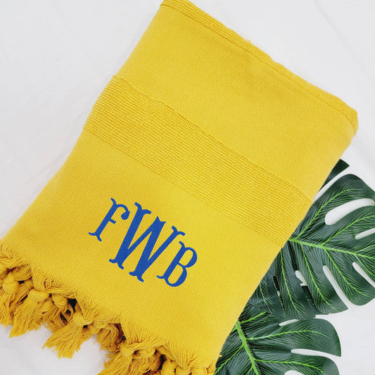 Mustard beach towel folded on poolside lounger