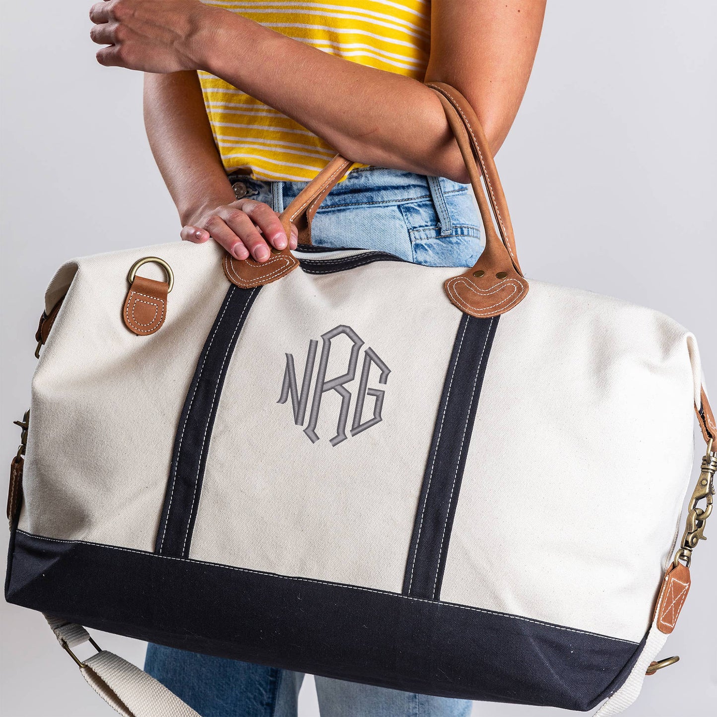 Navy canvas weekender bag with leather trim and brass hardware

