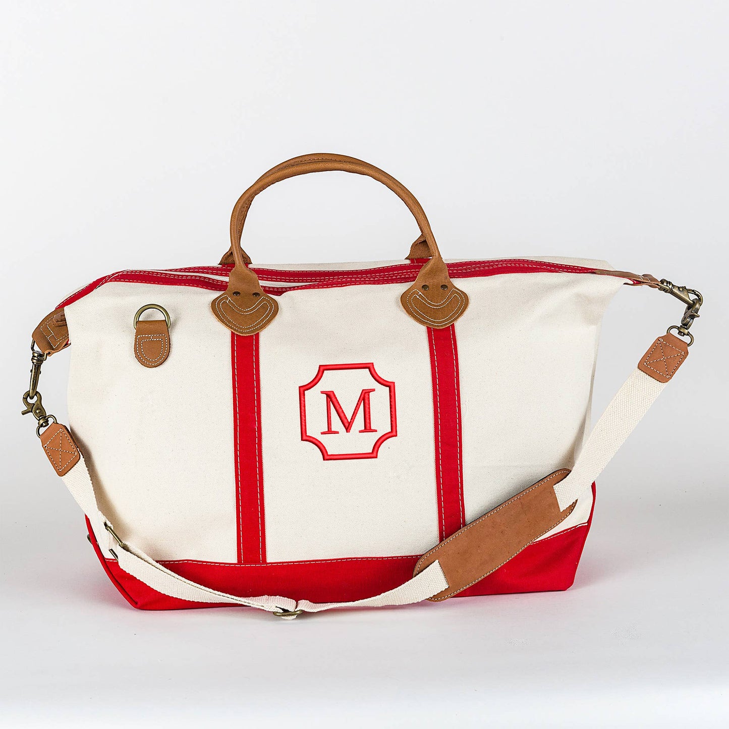 Red canvas duffel bag with shoulder strap and rolled leather handles