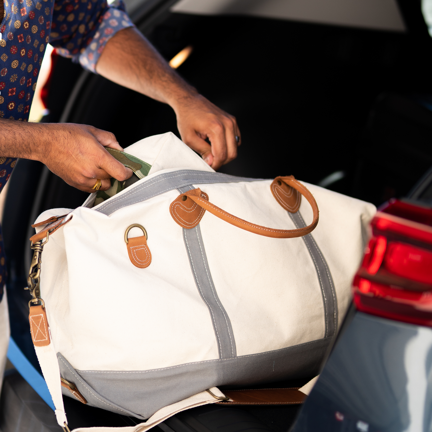 Stylish unisex weekender bag resting on luggage rack